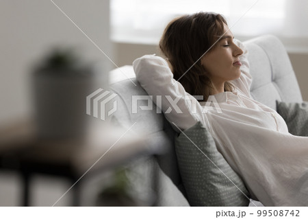 Calm pretty young woman resting on cozy sofa 99508742