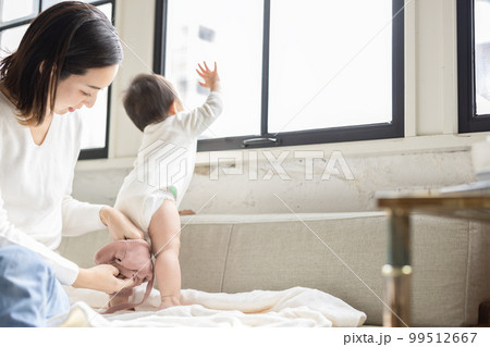赤ちゃんにズボンを履かせる母親 赤ちゃんにズボンを履かせる母親 99512667