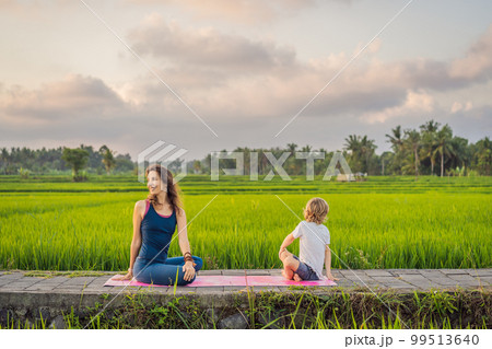 Boy and his yoga teacher doing yoga in a rice field Boy and his yoga teacher doing yoga in a rice field 99513640
