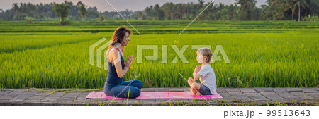 Boy and his yoga teacher doing yoga in a rice field BANNER, LONG FORMAT 99513643