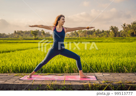 Young woman practice yoga outdoor in rice fields in the morning during wellness retreat in Bali Young woman practice yoga outdoor in rice fields in the morning during wellness retreat in Bali 99513777