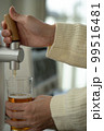 ビールサーバーからビールを注ぐ女性の手 99516481