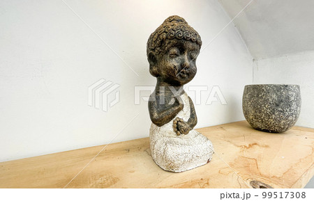 Small statue decorations for table and interior, little buddha statue modern simplistic house environment with several pottery and wooden table 99517308