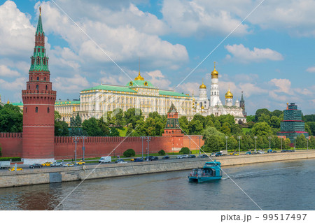 View of Kremlin with Vodovzvodnaya tower, Grand Kremlin Palace from repaired Bolshoy Kamenny Bridge in Moscow city on sunny summer day. Cruise ship sails on the Moscow river 99517497