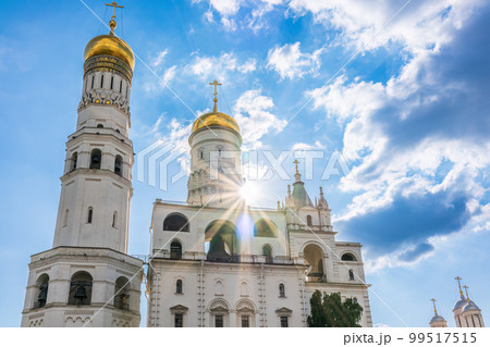 Ivan the Great Bell Tower, with Assumption Belfry on the right in Moscow Kremlin. Blue sky background with sunbeams 99517515