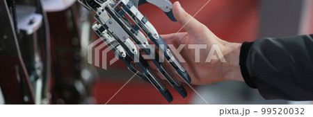 Robot extends its hand to man for handshake Robot extends its hand to man for handshake 99520032
