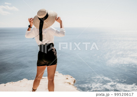 Woman sea hat. Business woman in yellow hat freelancer working over blue sea beach. Girl relieves stress from work. Freelance, digital nomad, travel and holidays concept Woman sea hat. Business woman in yellow hat freelancer working over blue sea beach. Girl relieves stress from work. Freelance, digital nomad, travel and holidays concept 99520617