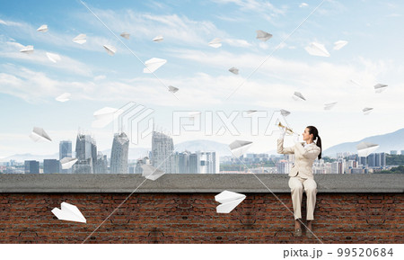 Elegant young woman playing trumpet 99520684