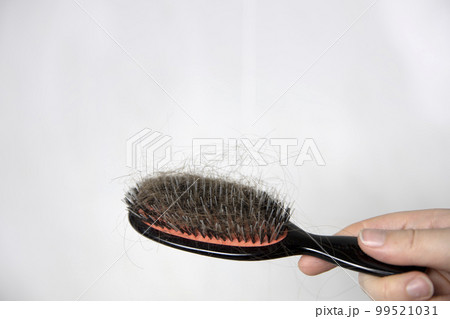 Hair loss problem, postpartum period, menstrual or endocrine disorder, hormonal disbalance, stress concept. Many hair fall after combing in hairbrush.Female untangles her hair with a comb, copy space 99521031