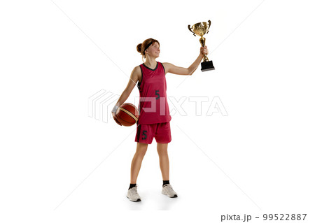 Winning game. Teen girl, basketball player posing with trophy, award isolated over white studio background. Concept of professional sport and hobby Winning game. Teen girl, basketball player posing with trophy, award isolated over white studio background. Concept of professional sport and hobby 99522887