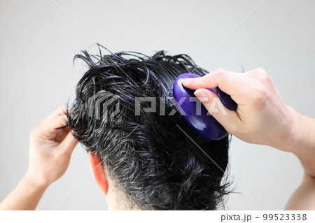 ヘアブラシで頭皮をマッサージする日本人男性	 99523338
