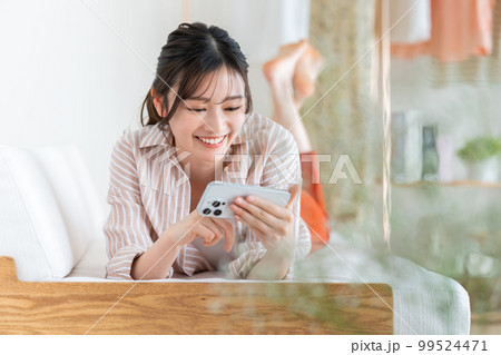 スマホで動画を見る若い女性 99524471