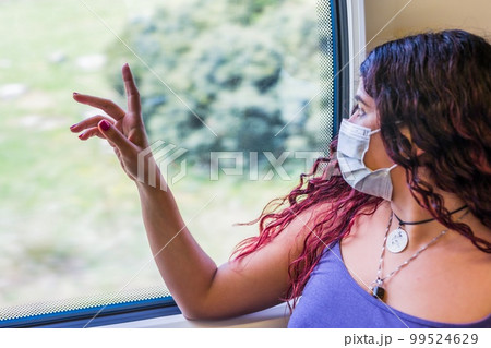 Train transport traveler passenger looking with emotion at window. Young venezuelan latin Tourist Train transport traveler passenger looking with emotion at window. Young venezuelan latin Tourist 99524629