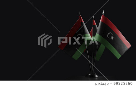 Small national flags of the Libya on a black background 99525260