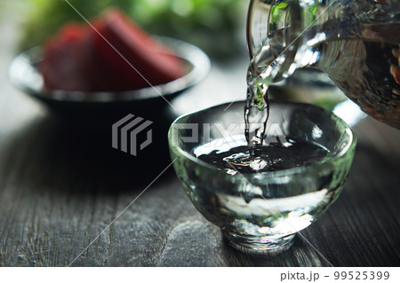 注がれる日本酒と漬け物(赤かぶ) 99525399