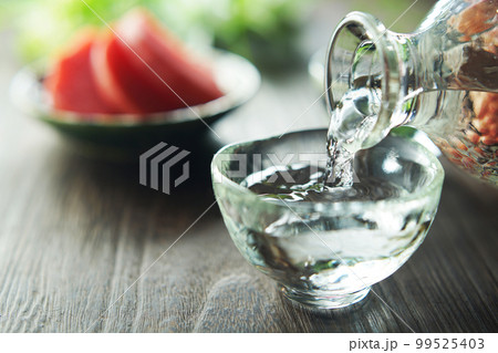 注がれる日本酒と漬け物(赤かぶ) 99525403