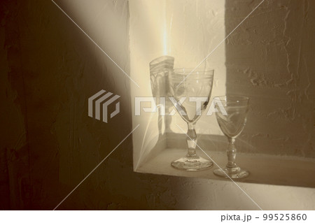 アペリティフグラスと王冠のオーナメントの光と影　グラスと宝石を散りばめた王冠オーナメントの光と影 99525860