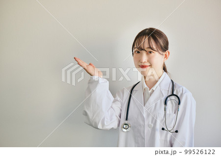 こちらのポーズをする若い女性医師 こちらのポーズをする若い女性医師 99526122