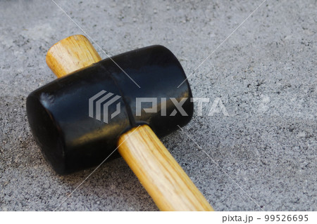 Defocus paving hammer close up. Garden brick pathway. Laying gray concrete paving slabs in courtyard on sand foundation base. Nobody. Out of focus 99526695