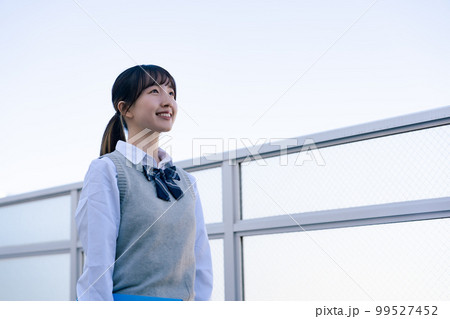 外で遠くを見る制服を着た女子高生 外で遠くを見る制服を着た女子高生 99527452
