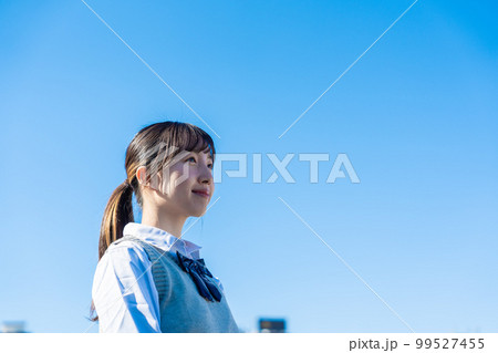 外で遠くを見る制服を着た女子高生 外で遠くを見る制服を着た女子高生 99527455