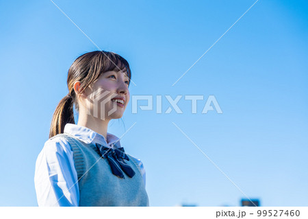 外で遠くを見る制服を着た女子高生 99527460