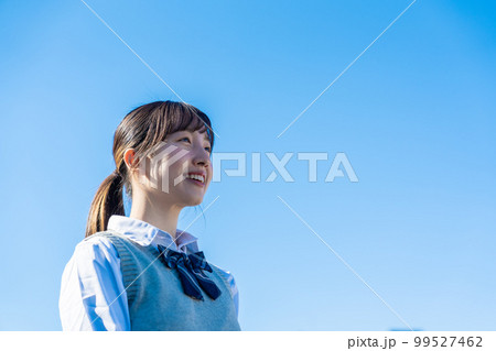 外で遠くを見る制服を着た女子高生 99527462