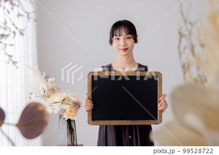 メッセージボードを持つワンピースの女性 99528722