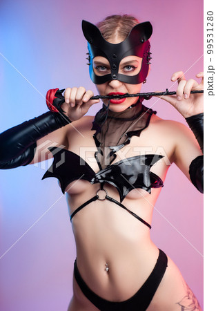 Sexy girl in bdsm underwear leather mask and leather rose for bdsm games costume for sex games on pink bright background copy paste 99531280
