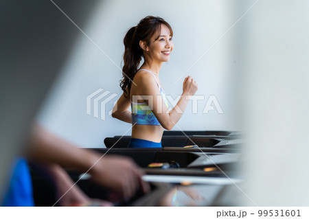 スポーツジムでトレーニングする若い女性 99531601