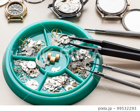 clock spare parts in tray on wooden table 99532293