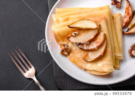Delicious fresh baked pancakes with honey and fruits on a concrete background 99533079