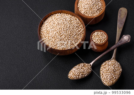 Wholesome raw quinoa in a bowl on a dark concrete background 99533096
