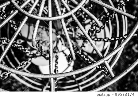 Top view of a golf basket chains with discs blurred below Top view of a golf basket chains with discs blurred below 99533174