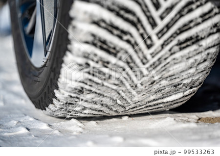 Closeup selective focus on snow packed in an all-weather tire tread. Closeup selective focus on snow packed in an all-weather tire tread. 99533263