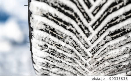Closeup selective focus on snow packed in an all-weather tire tread. 99533338