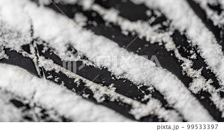 Closeup selective focus on snow packed in an all-weather tire tread. 99533397