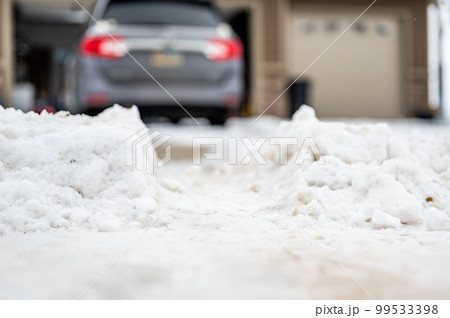 Snowbank at the end of a driveway left after city snowplows cleared a street. 99533398