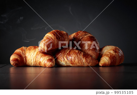 Freshly baked croissants on a black ceramic table. Freshly baked croissants on a black ceramic table. 99535105