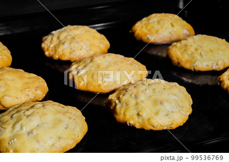 Cooking homemade crunchy oatmeal cookies on metal sheet in oven Cooking homemade crunchy oatmeal cookies on metal sheet in oven 99536769
