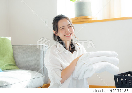 洗濯物を畳む女性　　 99537183