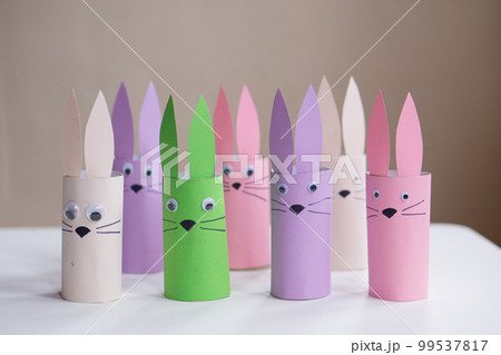 A banner from handmade easter bunny toy gift on a white table background. Paper easter rabbits. Happy easter. 99537817