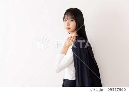 スーツを肩にかけるビジネスウーマン　背負う　担ぐ 99537960