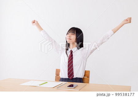 長時間の勉強に疲れてストレッチをする女子高生 99538177