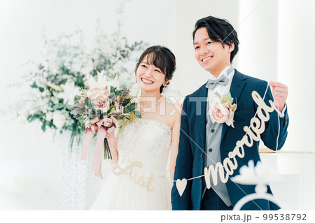 結婚式場でガーランドを持つ新郎新婦（ブライダル・ウェディング） 99538792