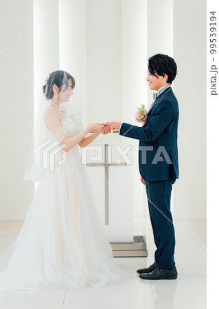 結婚式場で指輪交換する新郎新婦(結婚式・ウェディング・ブライダル) 結婚式場で指輪交換する新郎新婦(結婚式・ウェディング・ブライダル) 99539194