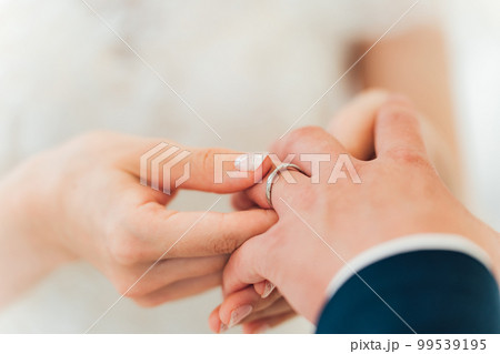 結婚式場で指輪交換する新郎新婦（結婚式・ウェディング・ブライダル） 99539195