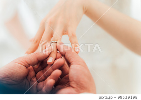 結婚式場で指輪交換する新郎新婦（結婚式・ウェディング・ブライダル） 99539198