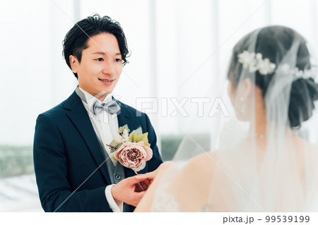 結婚式場で指輪交換する新郎新婦（結婚式・ウェディング・ブライダル） 99539199