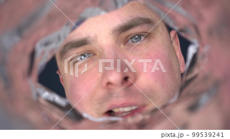 A young man screams into the empty package and waits for an answer. The man is upset. View of a man from below from a pack from the first person. A young man screams into the empty package and waits for an answer. The man is upset. View of a man from below from a pack from the first person. 99539241